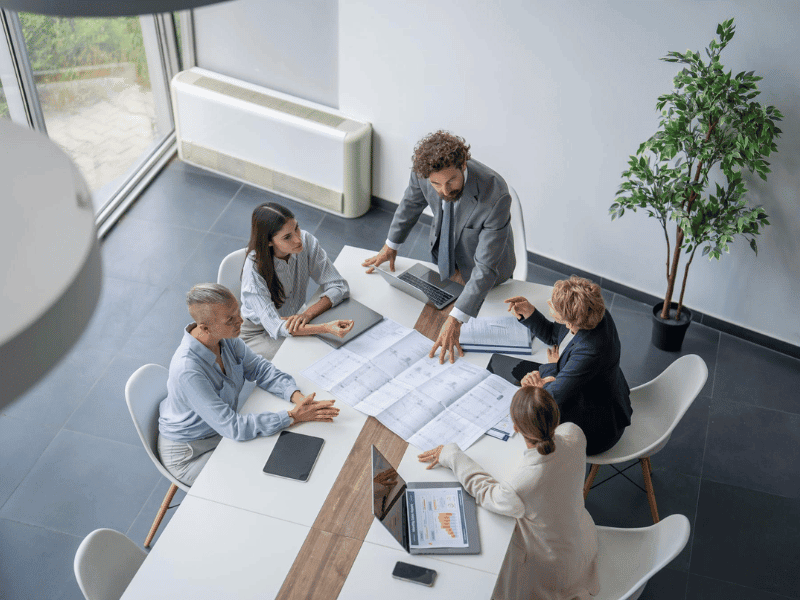 Commercial contract negotiation meeting between business professionals reviewing a services agreement